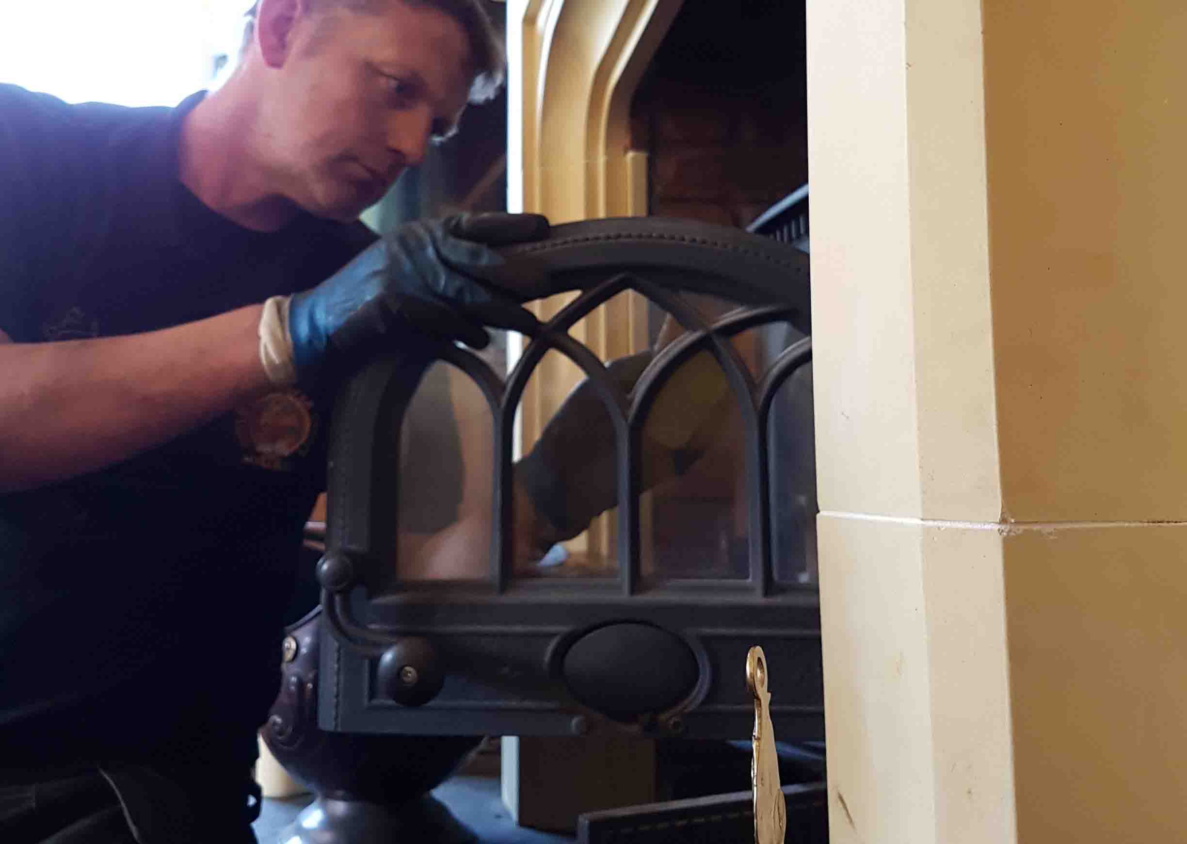 A Chimney Sweep servicing stove